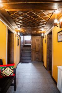 a hallway with yellow walls and wooden ceilings at Къща ЕТНО in Koprivshtitsa