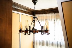 a chandelier hanging from a ceiling in front of a window at Къща ЕТНО in Koprivshtitsa