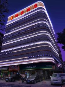 un gran edificio con coches estacionados frente a él en Guangzhou JinTang Hotel, en Guangzhou