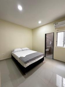 1 dormitorio con 1 cama grande y baño en Apartamentos sin fronteras, en Leticia