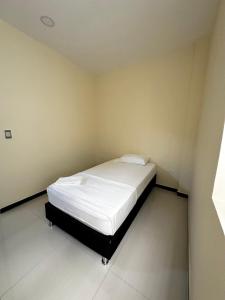 Un pequeño dormitorio con una cama blanca en una habitación en Apartamentos sin fronteras, en Leticia