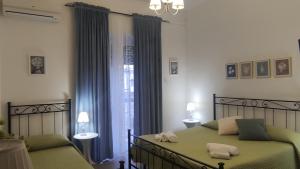 - une chambre avec 2 lits et une fenêtre dans l'établissement Anthea, à Naples