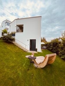 ein weißes Haus mit einer Bank im Hof in der Unterkunft Moderne Ferienwohnung zum Wohlfühlen in Lindenberg im Allgäu