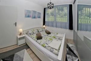 - une chambre avec un grand lit dans une pièce dotée de fenêtres dans l'établissement Cable Car Apartment Baščaršija, à Sarajevo