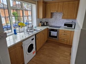 uma cozinha com um lavatório e uma máquina de lavar louça em Millmead Apartment in central Guildford with parking em Guildford