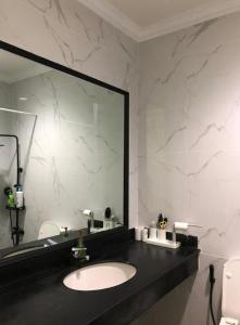 a bathroom with a sink and a large mirror at Apartemen Startegis di Mega Kuningan in Jakarta