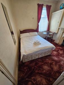 um quarto com uma cama e piso alcatifado em The 23 em Londres