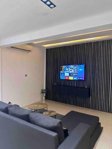 un soggiorno con divano e TV a schermo piatto di Gilviana Nights - East Legon/ Adjingarnor a East Legon