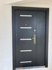 una porta nera in una stanza con un muro bianco di Gilviana Nights - East Legon/ Adjingarnor a East Legon