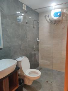 a bathroom with a toilet and a glass shower at Grand Manor Suites in Hyderabad