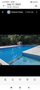 a picture of a blue swimming pool with a website at Sri Sai Farm House in Puducherry