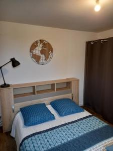 um quarto com uma cama e um relógio na parede em Aux Portes de Brest em Le Relecq-Kerhuon