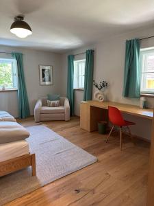 a bedroom with a bed and a desk and a chair at Traumurlaub auf dem Brandmanngut in Marquartstein