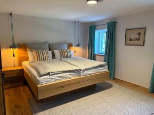 a bedroom with a large bed with green curtains at Traumurlaub auf dem Brandmanngut in Marquartstein