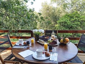 - une table en bois avec de la nourriture et des boissons sur une terrasse dans l'établissement Chalets du golfe de st Tropez l olivier, à La Garde-Freinet