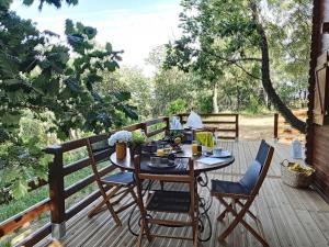 une terrasse en bois avec une table et des chaises. dans l'établissement Chalets du golfe de st Tropez l olivier, à La Garde-Freinet
