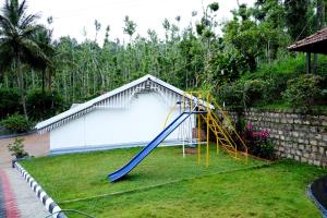 een speeltuin in een tuin met een glijbaan bij Cozy Tent Stay by Jungle Greens Homestay in Chikmagalūr