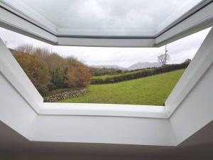 a window in a room with a view of a field at Mourne Views 2 Bed Apartment in Kilkeel