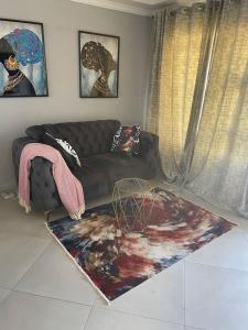 a living room with a couch and a rug at Tranquility at Homely Escape in Phalaborwa