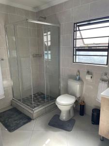 uma casa de banho com um chuveiro e um WC. em Tranquility at Homely Escape em Phalaborwa