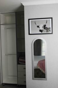 a picture of a cow in a mirror in a room at Tranquility at Homely Escape in Phalaborwa