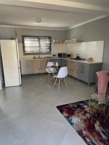 uma cozinha com um frigorífico, uma mesa e cadeiras em Tranquility at Homely Escape em Phalaborwa