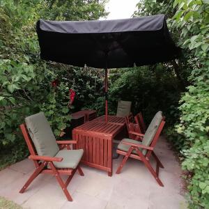 a picnic table with chairs and an umbrella at Ferienhaus Hygge in Flensburg