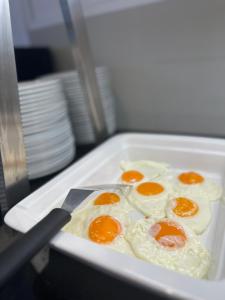 a white tray with eggs and a knife at Nicolas Grand Suites, Adults Only in Kardamaina