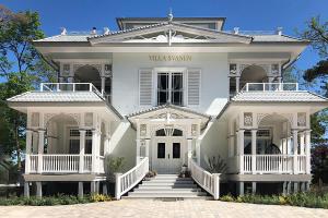 una casa bianca con portico bianco e scale di Villa Svanen am Meer a Timmendorfer Strand