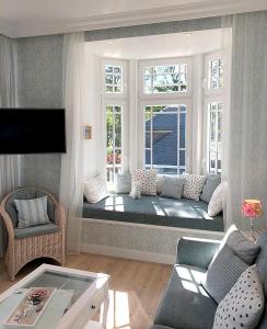 a living room with a couch in front of a window at Villa Svanen am Meer in Timmendorfer Strand