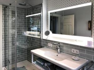 a bathroom with a sink and a mirror and a shower at Villa Svanen am Meer in Timmendorfer Strand