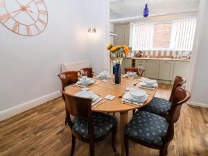 a dining room with a wooden table and chairs at Through the Looking Glass in Ripon