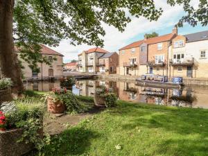 a view of a river in a town with houses at Through the Looking Glass in Ripon