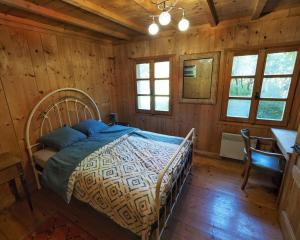 a bedroom with a bed in a wooden cabin at Le Doubs Chalet - Chalet Garnache in Oye-et-Pallet