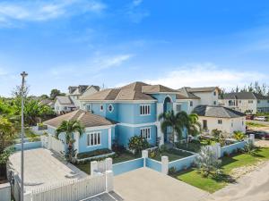 ein großes blaues Haus mit Palmen und Häusern in der Unterkunft Blu Diamond Luxury Estate in Nassau