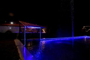 a lit up pool at night with blue lights at Rama Hills Unity Resort in Lāchharas