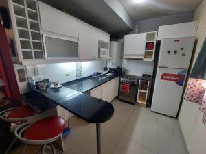 una pequeña cocina con encimera negra y refrigerador en Mendoza en Mendoza