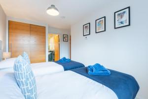 two beds in a bedroom with blue towels on them at Parkview, St Andrews in St. Andrews