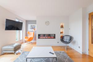 a living room with a fireplace and a chair at Parkview, St Andrews in St. Andrews +17 photos