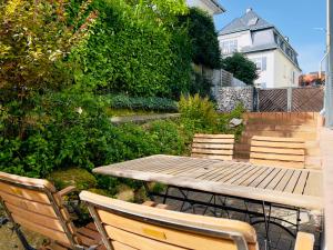 una mesa de madera y sillas en un jardín en Ferienwohnungen am Bürgerpark en Bad Nauheim