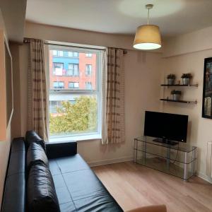 a living room with a couch and a large window at Parnell Apartments in Dublin