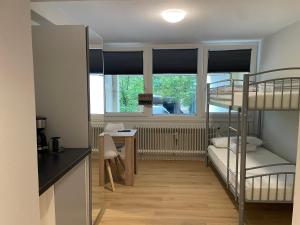 a room with two bunk beds and a desk at Süßes kleines und zentrales Apartment für zwei Personen mitten in Hamburg in Hamburg
