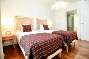 una camera con due letti, un tavolo e una lampada di Green Algarve Retreat in Faro with a Terrace Bliss a Faro