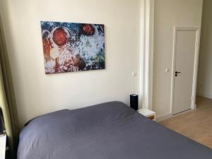 1 dormitorio con 1 cama y una pintura en la pared en Mastbos Guesthouse Breda en Breda