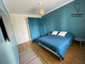 - une chambre bleue avec un lit et une table dans l'établissement Les chambres du Graoully - Le 109 - Metz Gare - Parking inclus - NO S-model, à Metz