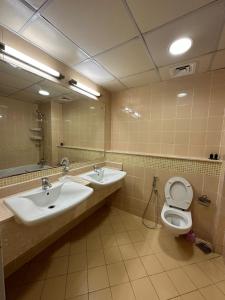 a bathroom with two sinks and a toilet and a mirror at Ruby Star Hostel Dubai for Female -4 R-1 in Dubai
