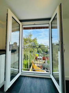 um quarto vazio com uma grande janela e uma varanda em Twickenham Apartments by Charles em Teddington