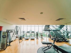 un gimnasio con filas de cintas de correr y máquinas de ejercicio en Serenity Saigon Sky Villas en Ho Chi Minh