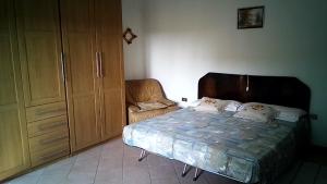 1 dormitorio con 1 cama y 1 silla en CASA MAMMA, en Camponogara