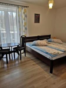 een slaapkamer met een bed en een tafel bij Ośrodek Wypoczynkowy Nad Stawem in Kudowa-Zdrój
